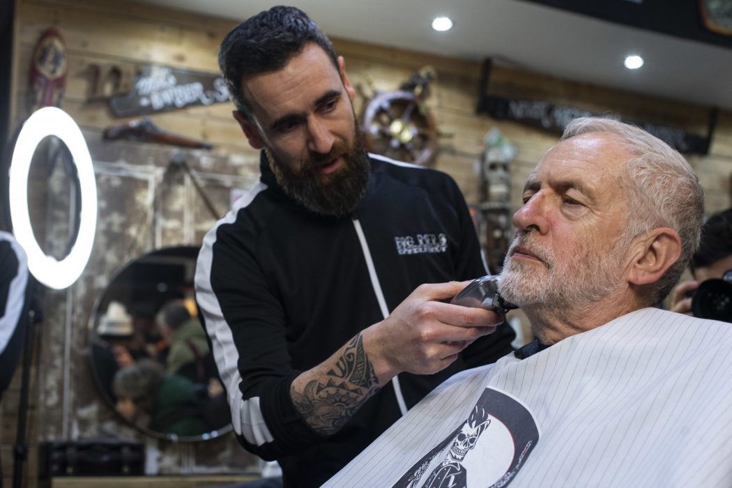 Labour Party leader Jeremy Corbyn has his beard trimmed in Big Mel's Barbershop, Carmarthen, while on the General Election campaign trail in Wales, Saturday, Dec. 7, 2019. Britain goes to the polls on Thursday, Dec. 12. (Victoria Jones/PA via AP) TH804 Labourledaren Jeremy Corbyn får skägget ansat under ett stopp på sin valturné