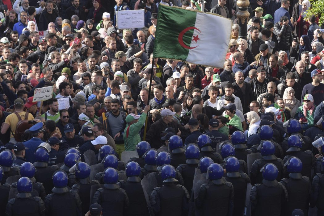 Säkerhetsstyrkor på rad framför demonstranter i Algeriets huvudstad Alger under protester på onsdagen.