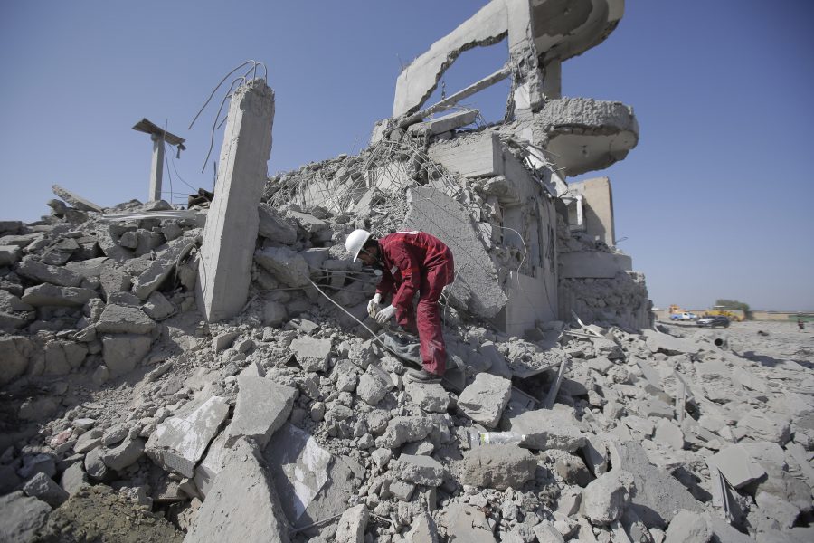 En räddningsarbetare letar överlevande i ruinerna efter en saudisk-ledd flygbombning i Jemen.