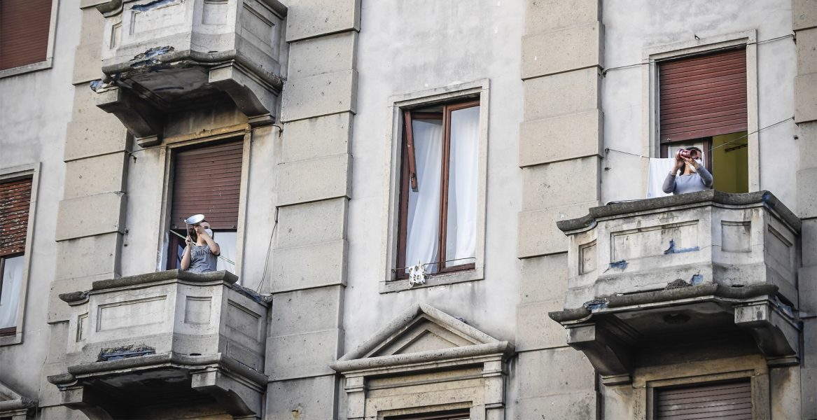 Italienare i karantän går ut på sina balkonger och sjunger och spelar tillsammans.