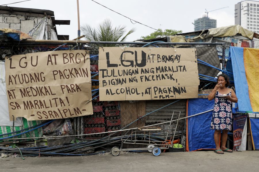 En handskriven skylt i ett slumområde i Manila vädjar om mat och medicinsk utrustning till den filippinska huvudstadens fattiga.