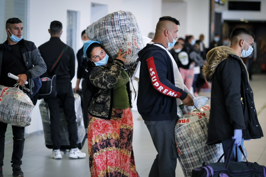 Rumäner som rekryterats för att arbeta i det brittiska lantbruket köar på flygplatsen i Bukarest den 8 maj.