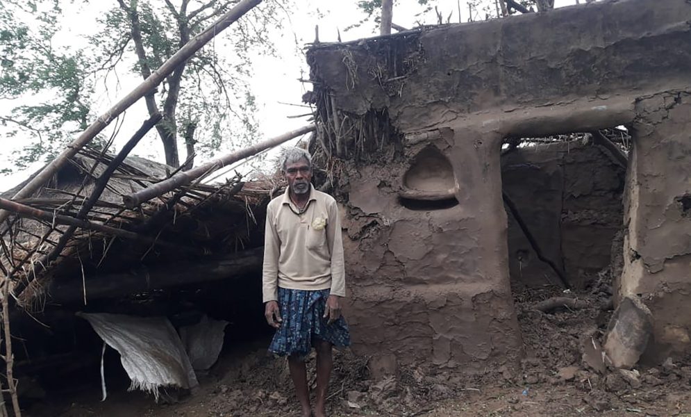 En bybo framför sitt hus som skadats av cyklonen Amphans framfart i distriktet Bhadrak i delstaten Odisha i Indien.