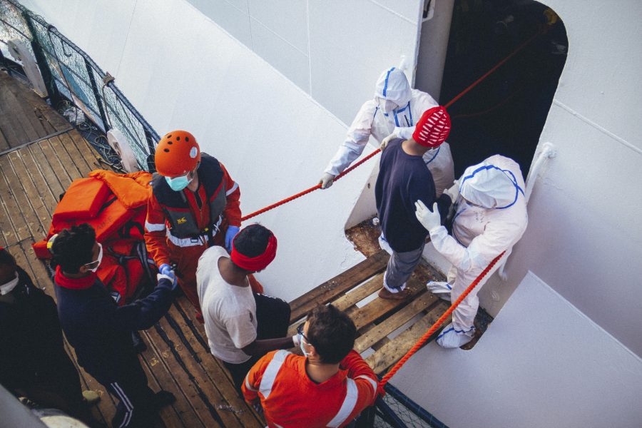 Flyktingar flyttas från fartyget Alan Kurdi, som tillhör organisationen Sea-eye, för att sättas i karantän på ett annat fartyg under 14 dagar.