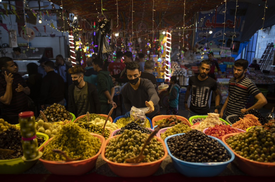 En försäljare av inlagda grönsaker bär munskydd på marknaden Zawiya i Gaza City.