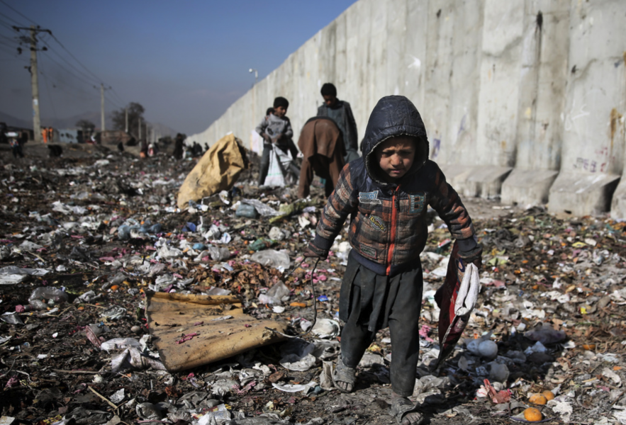 Ett barn letar efter bränsle på en soptipp i Afghanistans huvudstad Kabul.