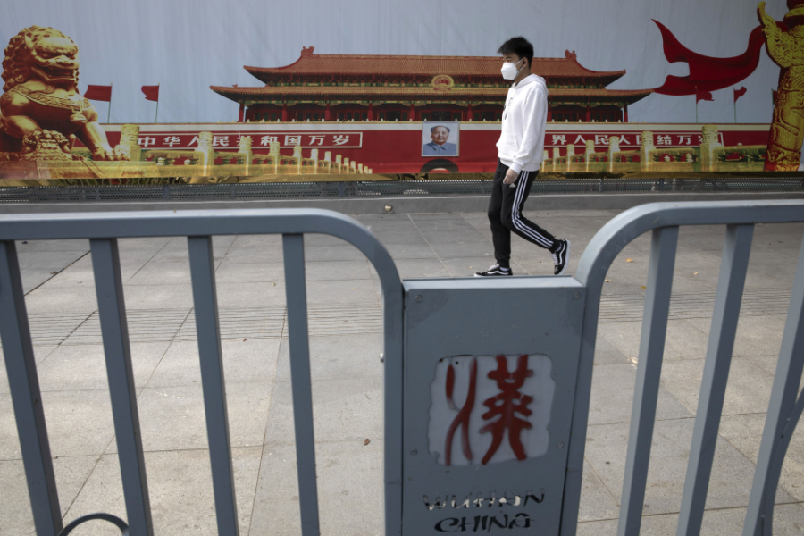 En man på promenad i den kinesiska staden Wuhan, där det nya coronaviruset först upptäcktes.