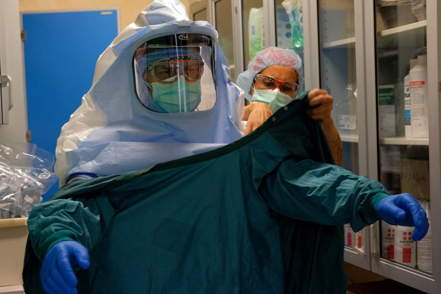 En sjuksköterska hjälper en kollega att sätta på sig skyddsutrustning vid en covid-19-avdelning i Rom i mitten av april.