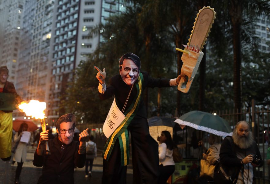 Demonstrant bär en mask föreställande president Bolsonaro och en motorsåg under en pro-Amazonas protest mot presidenten under skogsbränderna i september förra året.