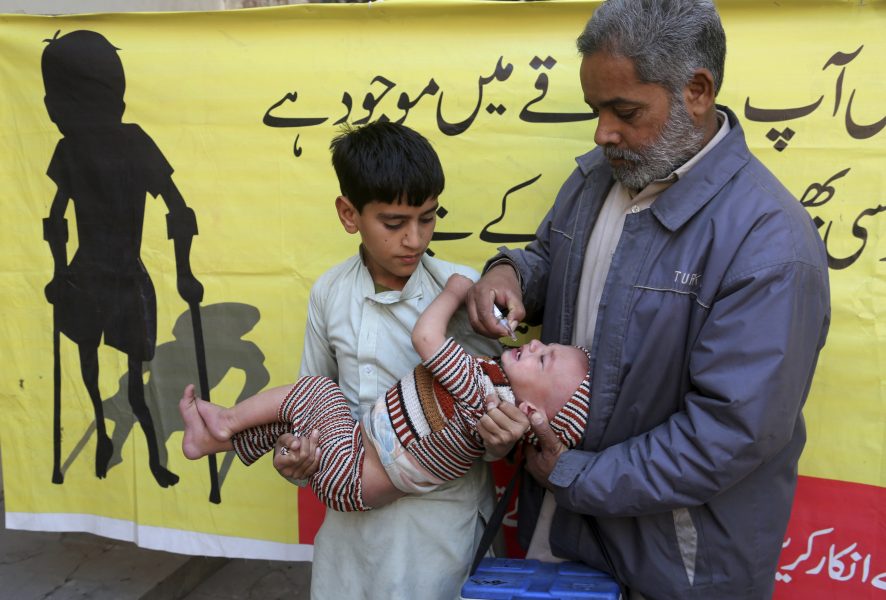 Ett barn i Pakistan får poliovaccin av en hjälparbetare i februari i år.