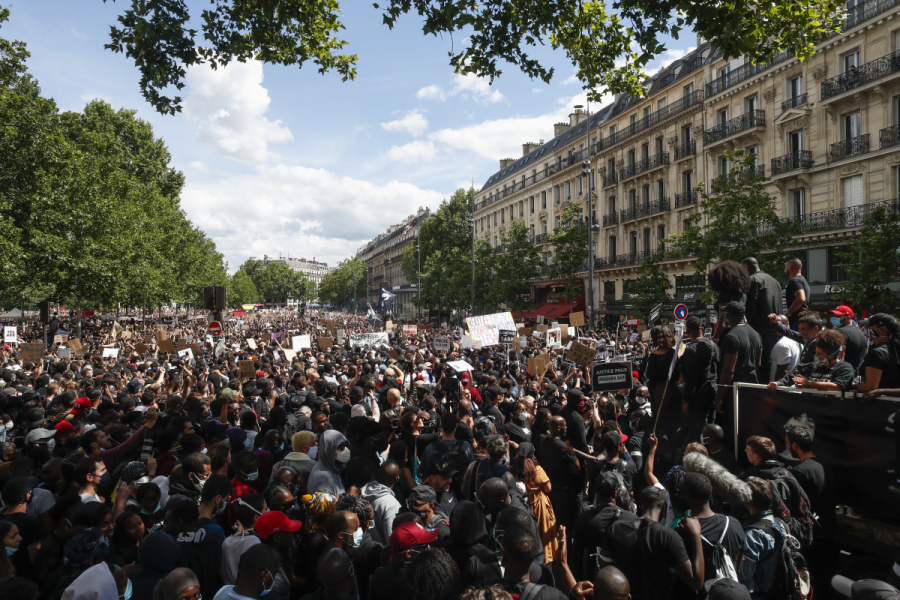 Folk lyssnar till Assa Traore under en demonstration mot polisbrutalitet och rasism i Paris, Frankrike, lördagen den 13 juni 2020.