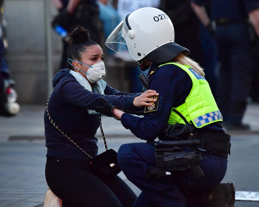 Kravallpolis och en demonstran vid Norrbro i Stockholm på onsdagskvällen.
