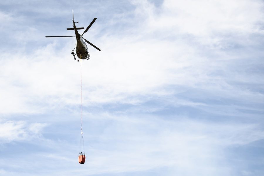 En helikopter vattenbombar det branddrabbade området runt Färila i Hälsingland sommaren 2018.