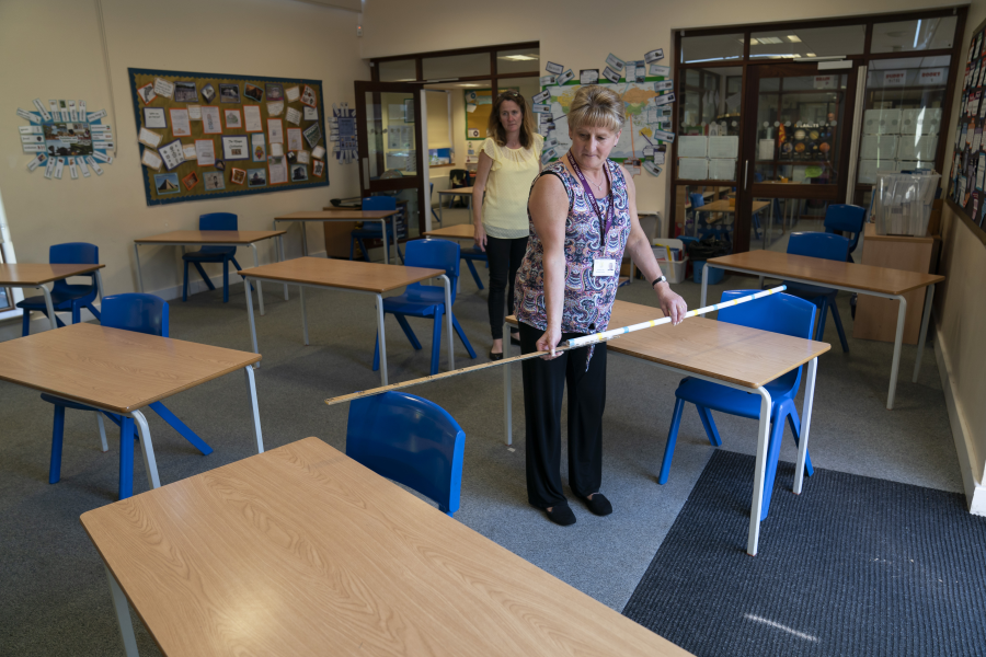 Jane Cooper, lärare i sjätte klass, kontrollerar avståndet mellan skolbänkarna i sitt klassrum i skolan Lostock Hall i Poynton i närheten av Manchester.