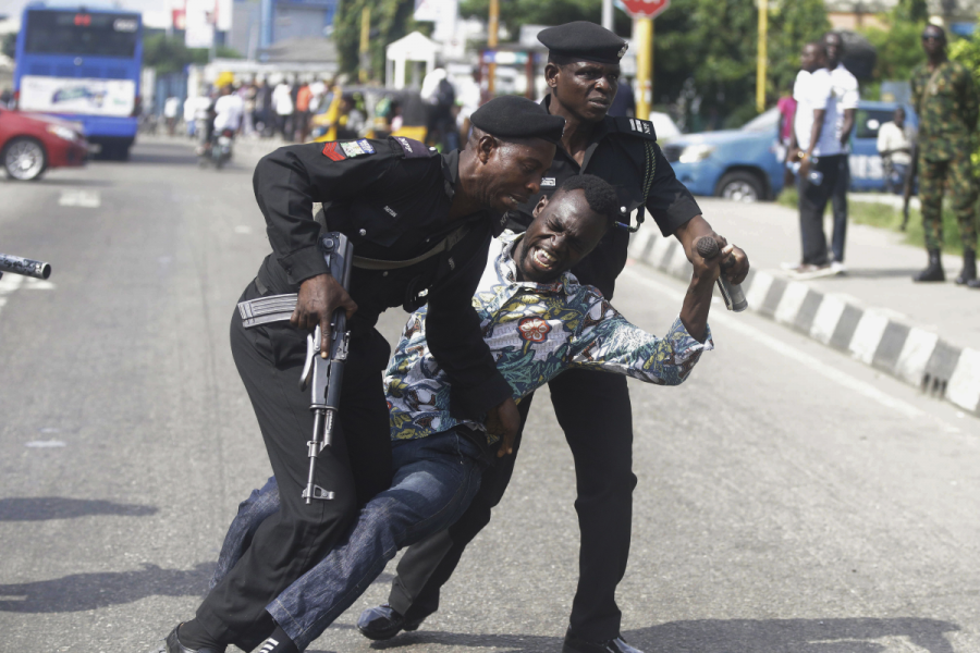 Polis i Nigeria för bort en journalist under en demonstration i landets största stad Lagos i fjol.