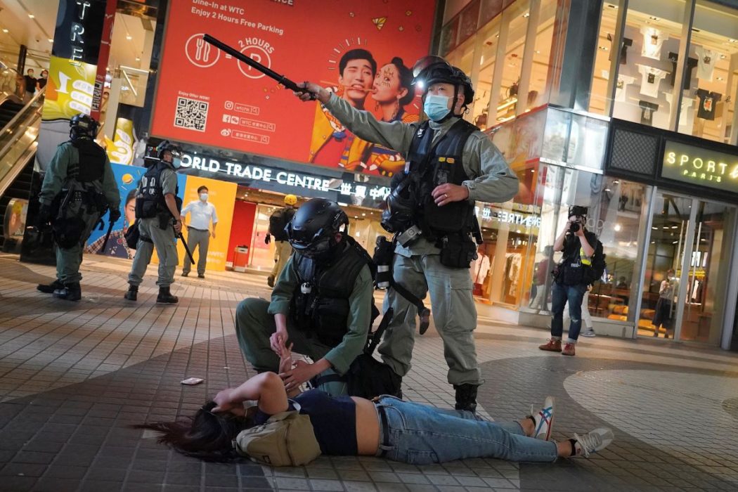 Kravallpolis i Hongkong griper en demonstrant under en protest den 12 juni.
