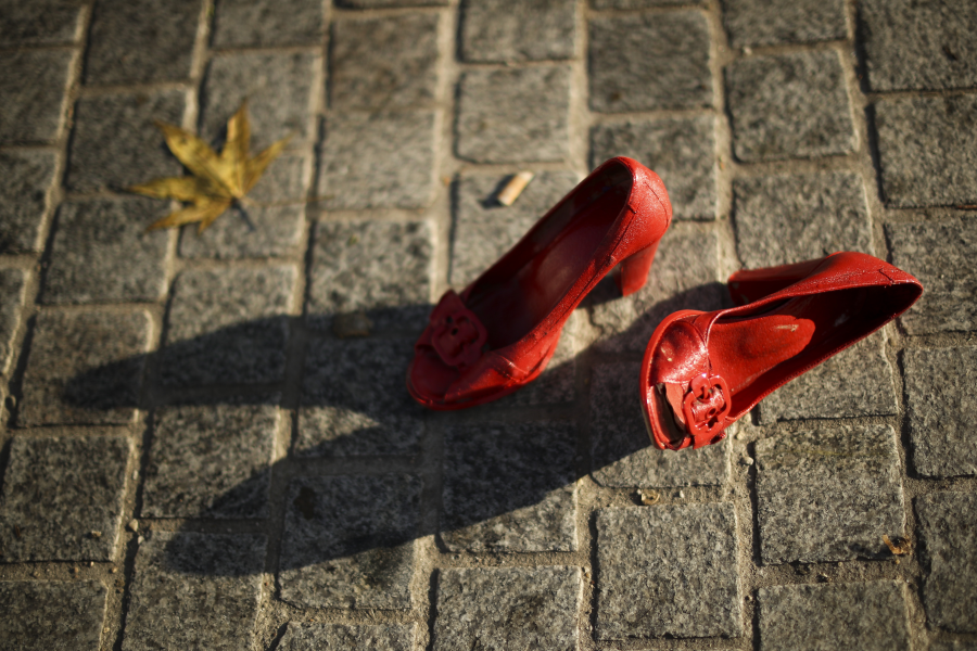 Ett par skor ligger på marken bland andra dussintals rödmålade skor som en del av en installation mot våld mot kvinnor i Bryssel förra året.