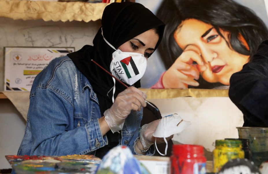 Den palestinska konstnären Samah Saed dekorerar en ansiktsmask för att få fler att bära ansiktsmask i Gaza.