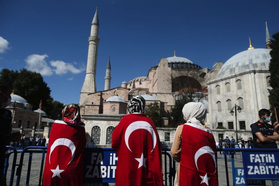På bilden syns Hagia Sofia i bakgrunden, och i förgrunden personer svepta i turkiska flaggan.