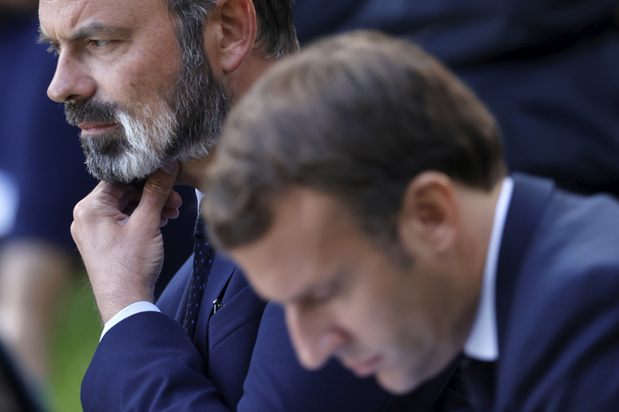 Frankrikes president Emmanuel Macron får ombilda sin regering då premiärminister Édouard Philippe (i bakgrunden) avgår.