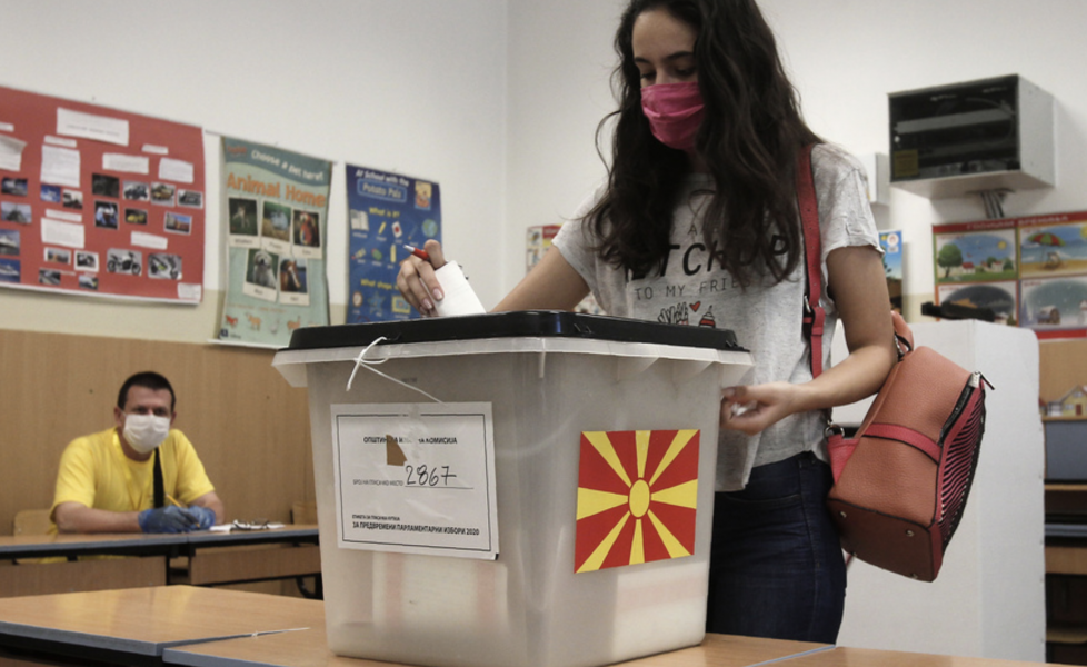 En väljare med munskydd lägger sin röst i det nordmakedonska parlamentsvalet i Skopje.
