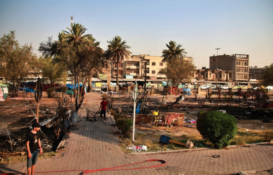 Demonstranter inspekterar nedbrända tält i närheten av Tahrirtorget i Bagdad efter de nya protesterna.