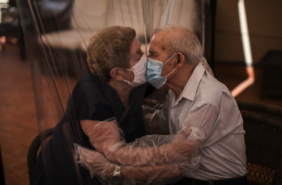 Agustina Canamero, 81, och Pascual Pérez, 84, omfamnar varandra genom ett plastskynke på ett äldreboende i spanska Barcelona 22 juni.