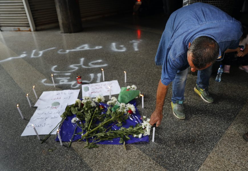 En man tänder ett ljus på Hamra Street, på den plats där en man tog sitt liv på grund av landets ekonomiska kris.