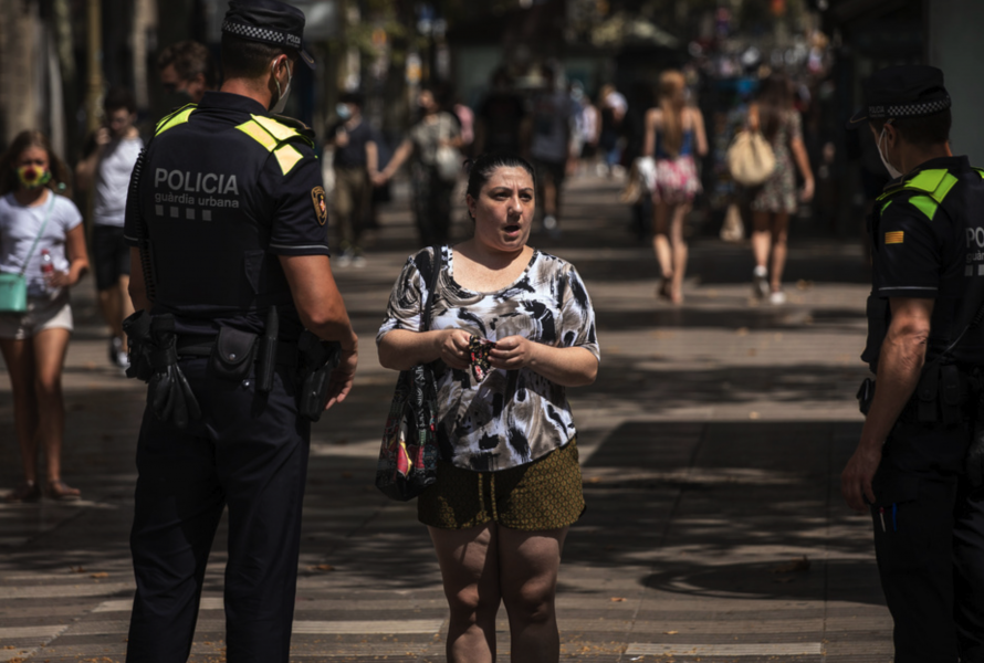 Katalansk polis säger till en kvinna att det är obligatoriskt att bära munskydd.