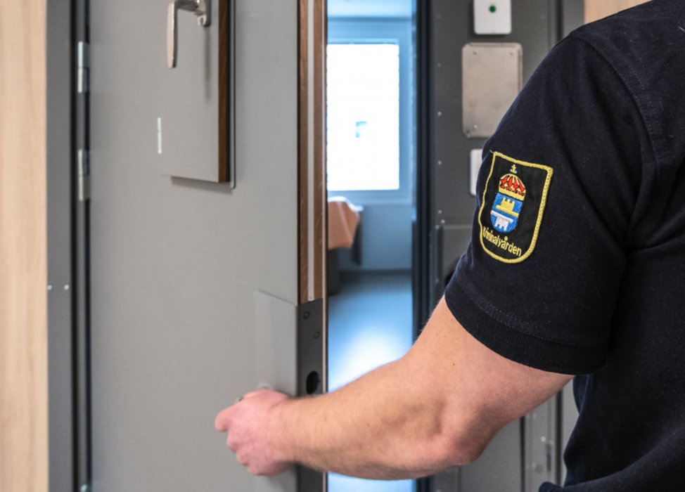 Kriminalvårdare öppnar en celldörr.