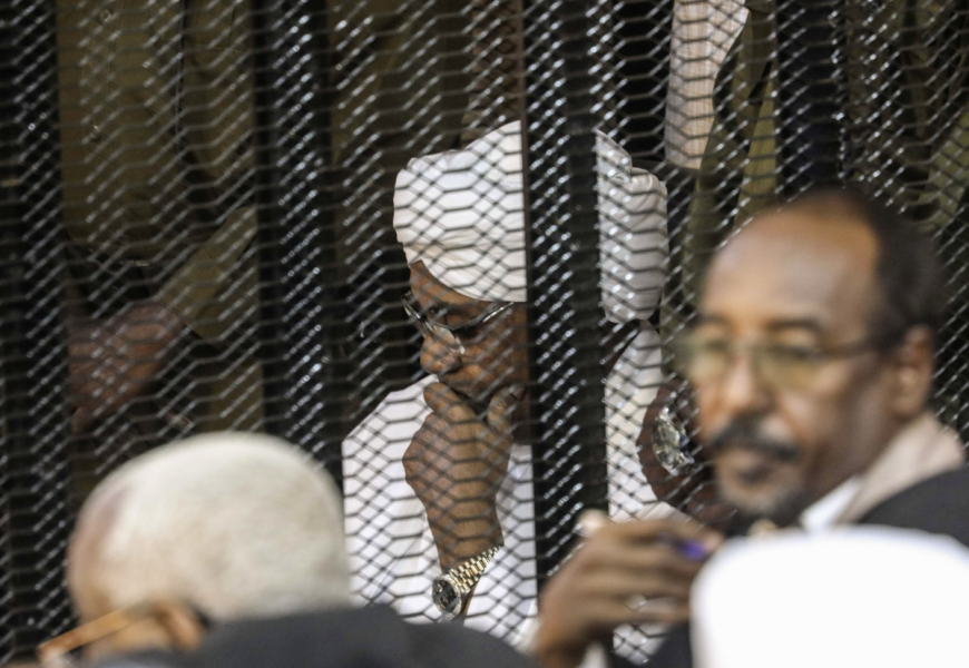 Sudans mångårige president Omar al-Bashir sitter i en bur under rättegången om korruption 2019.