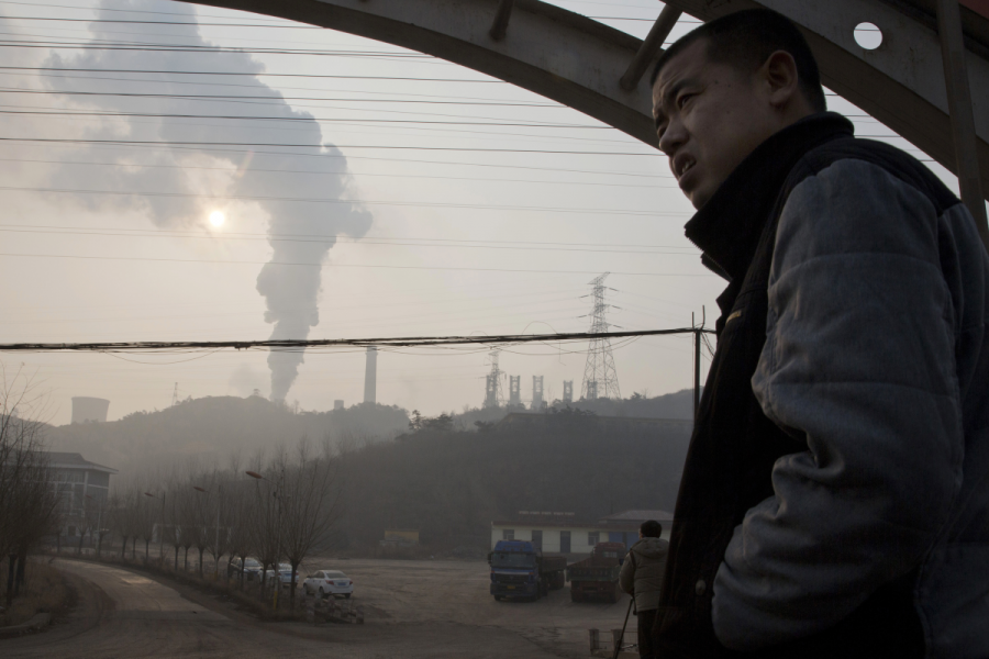 En man tittar ut över ett industrilandskap i Qianan i Hebei.