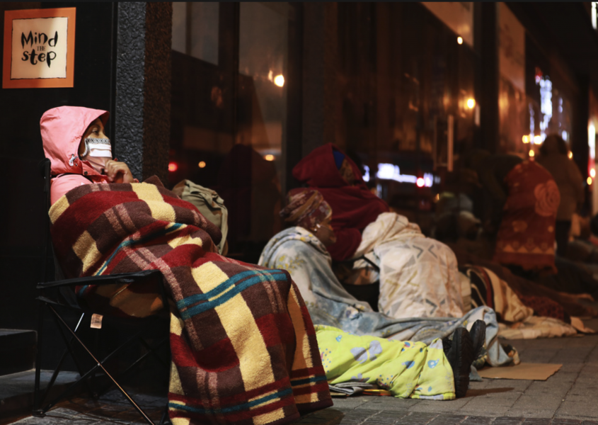 Kvinnor köar före gryningen för att ansöka om ekonomiskt stöd i Kapstaden, Sydafrika, under landets nedstängning i maj.