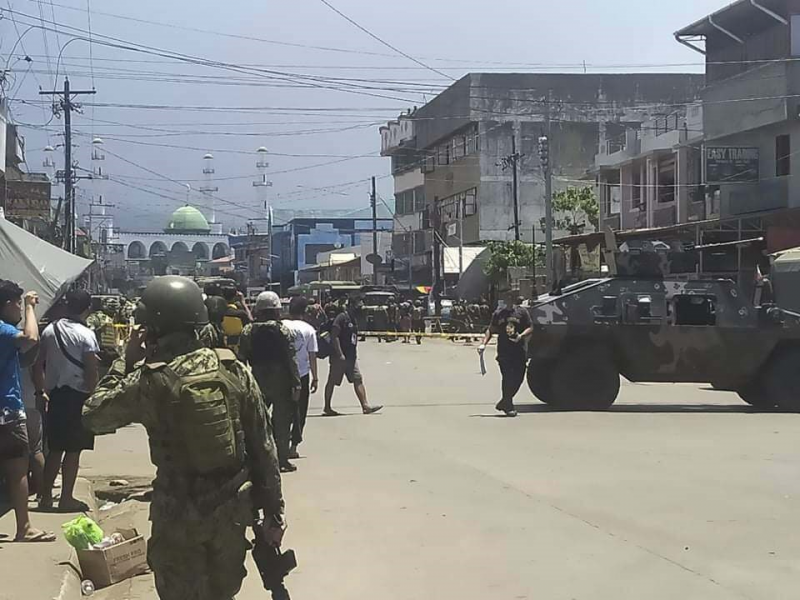 Soldater säkrar ett område i staden Jolo efter de två explosionerna på måndagen.