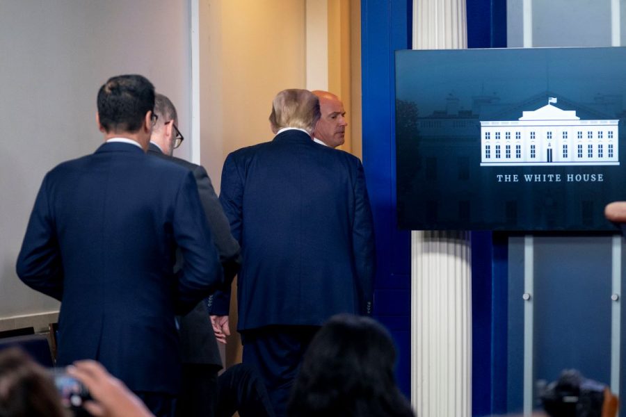 President Donald Trump lämnar presskonferensen tillsammans med personal från Secret Service.
