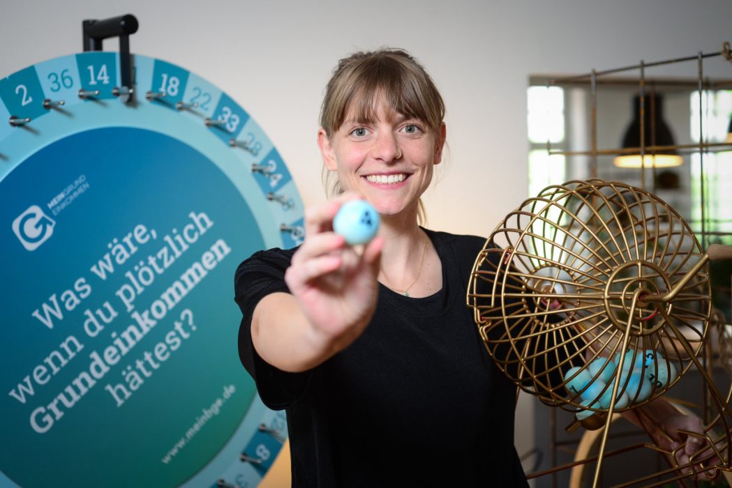 Initiativtagare till basinkomstförsöket är föreningen Mein Greundeinkommen (min basinkomst), som sedan 2014 lottat ut ettårig basinkomst till 669 personer.