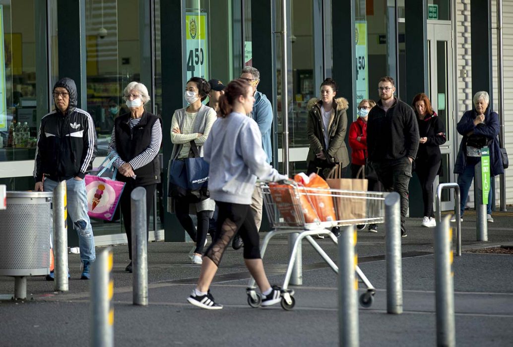 Människor köar utanför en livsmedelsbutik i Auckland.