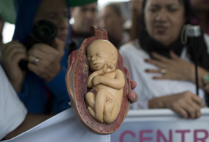 En abortmotståndare håller upp ett foster i plast under ett event skapat av katolska kyrkan i Brasilien.