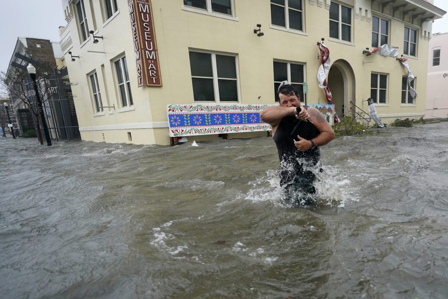 Trent Airhart vadar genom en översvämmad gata, onsdagen den 16 september, i centrala Pensacola.