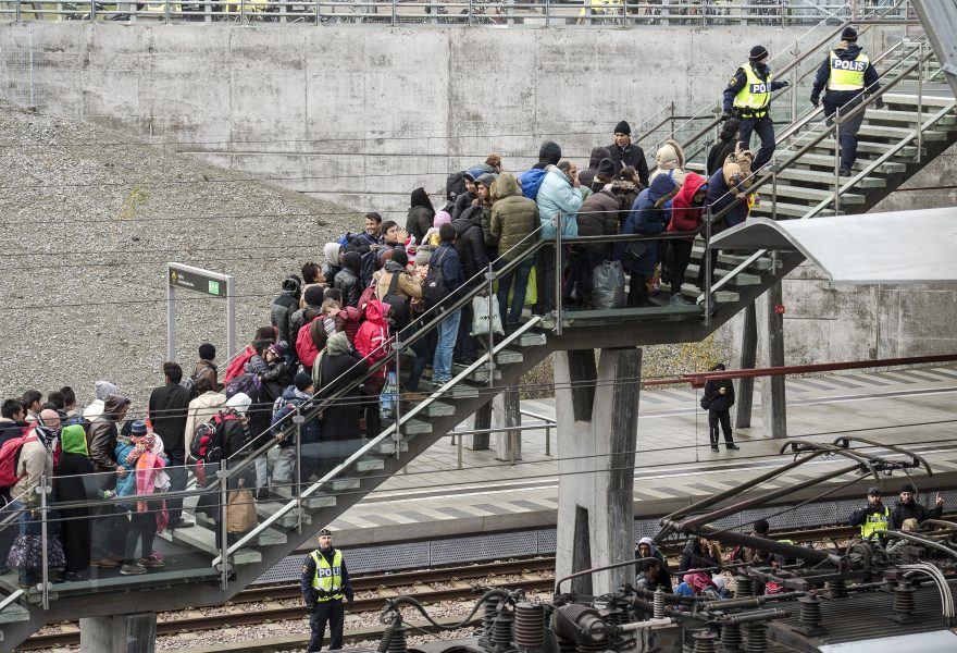 Polis övervakar kön av ankommande flyktingar i snålblåsten vid Hyllie station i Malmö i september 2015.