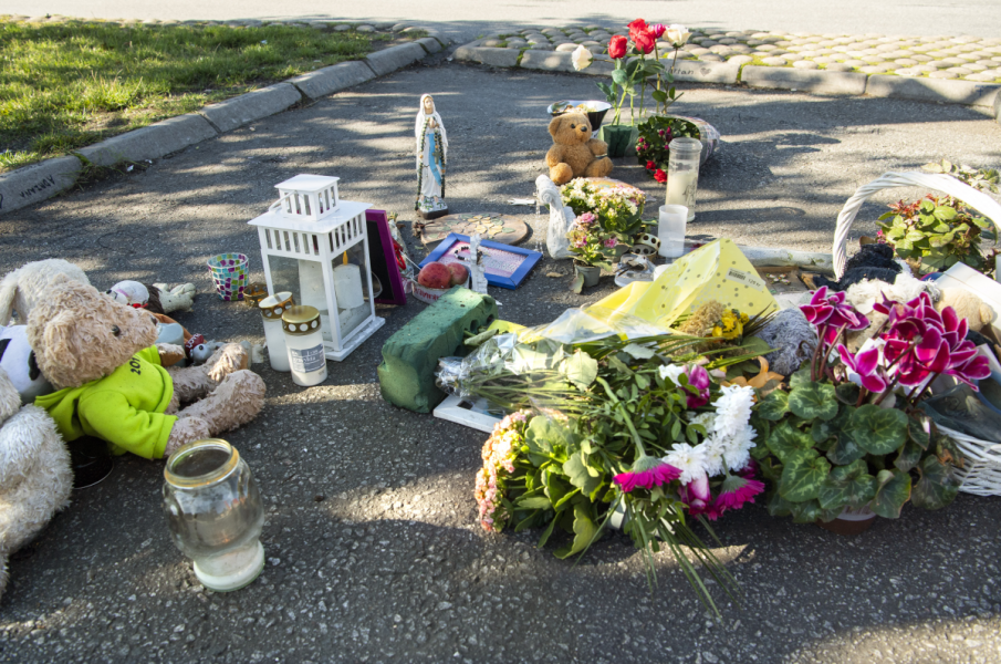 Blommor och nallar vid platsen där en tolvårig flicka sköts till döds i Botkyrka, tidigare i sommar.