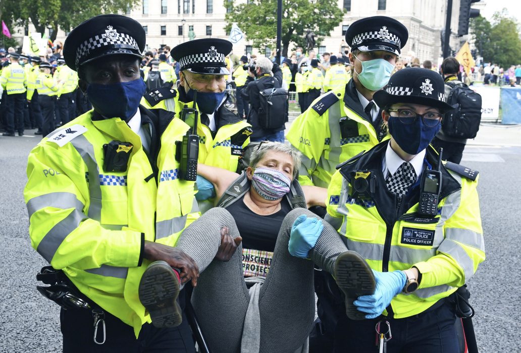 Polisen lyfter iväg en klimataktivist i centrala London.