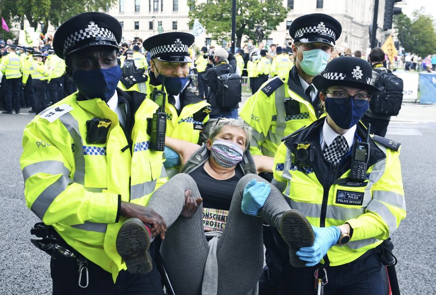 Polisen lyfter iväg en klimataktivist i centrala London.