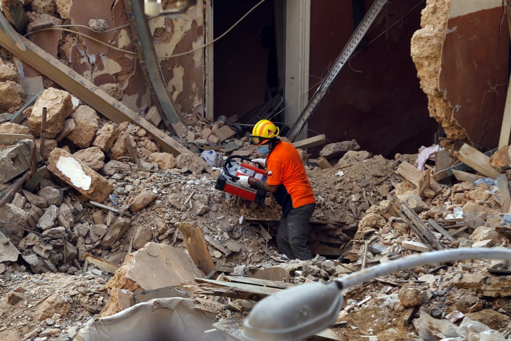 En chilensk räddningsarbetare letar efter livstecken i rasmassorna i Beirut.