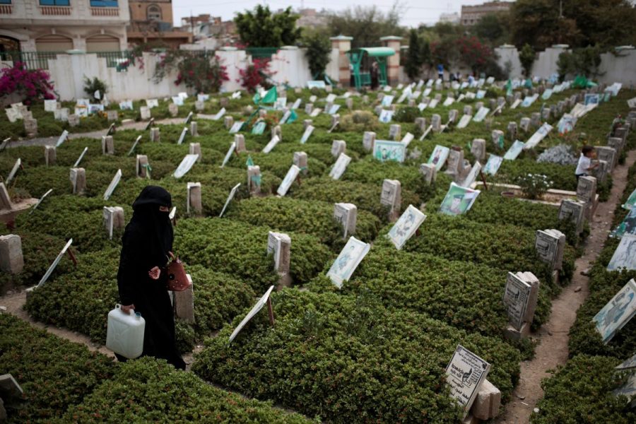 En kvinna går på en kyrkogård i Sanaa i Jemen, där offer för den pågående konflikten ligger begravda.