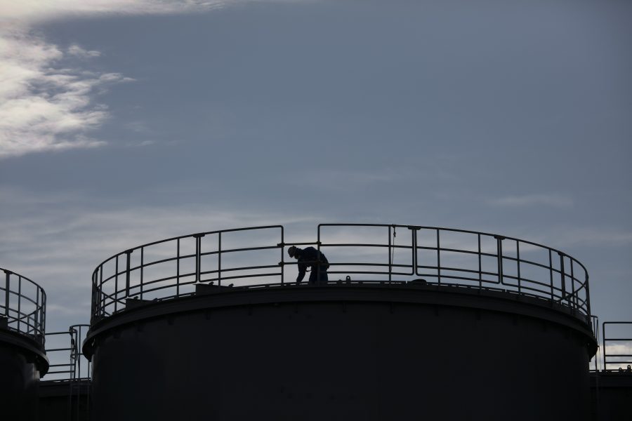 En arbetare ovanpå en nybyggd vattentank vid kraftverket Fukushima Daiishi tidigare i år.
