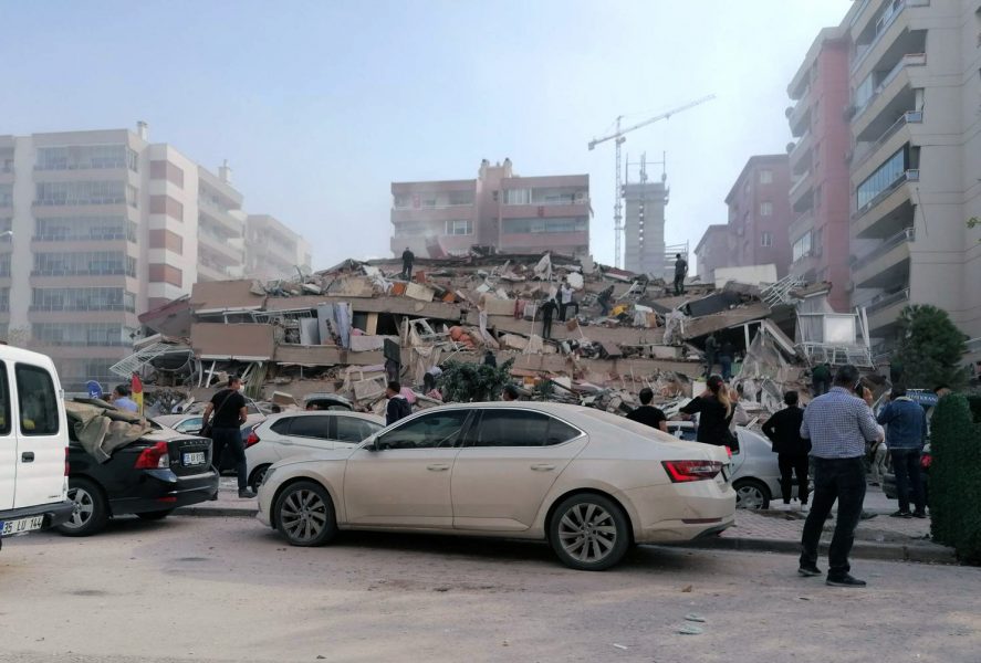 Räddningsarbetare och personer ur allmänheten försöker rädda människor som fastnat under en raserad byggnad Izmir i Turkiet efter fredagens kraftiga jordskalv.