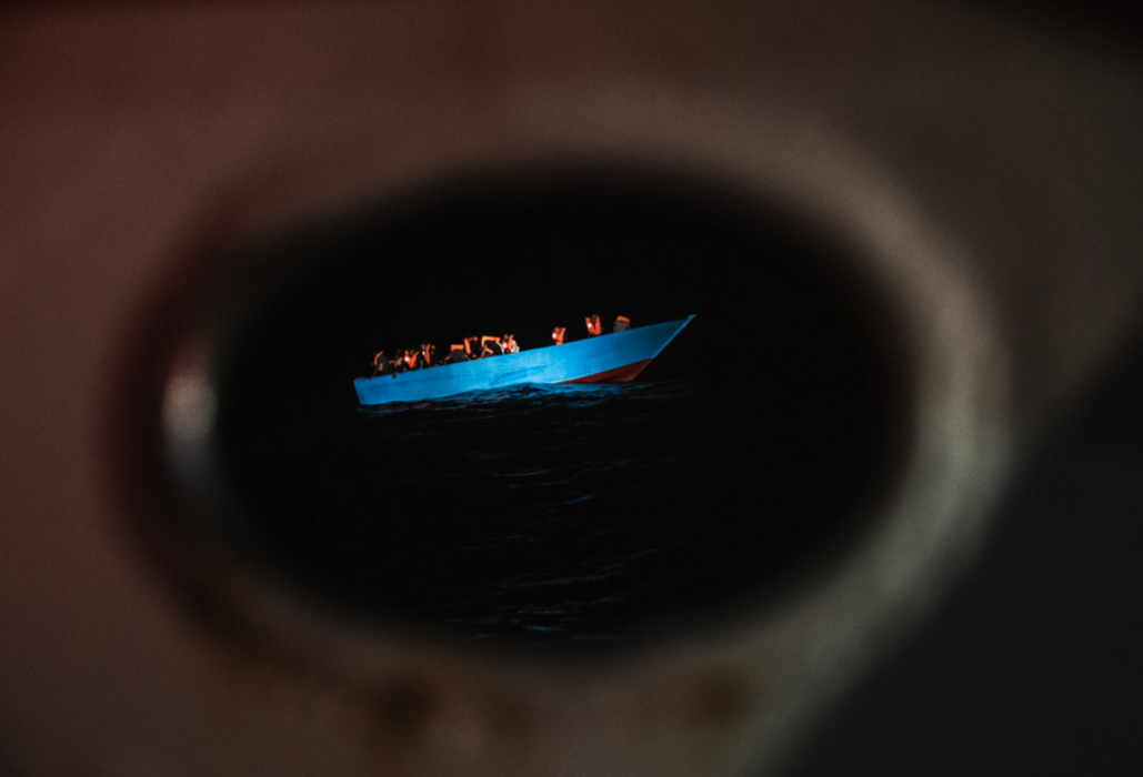 Migranter på en enkel båt i Medelhavet väntar på räddning i september i år.