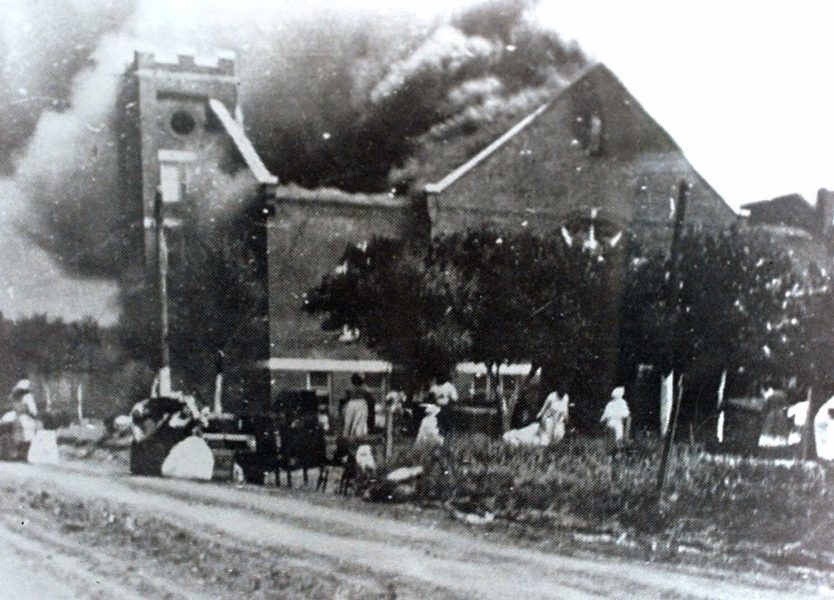 En kyrka i lågor efter att ha stuckits i brand av de vita mobbar som attackerade Greenwood i Tulsa, Oklahoma, 1921.