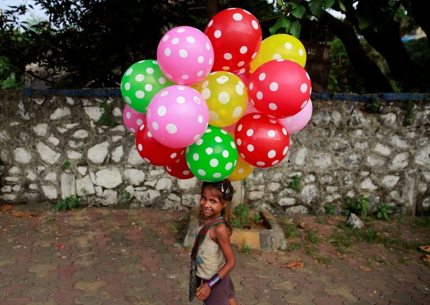Flickan Lali säljer ballonger på en strand i Mumbai i Indien, på internationella flickadagen för fem år sedan.